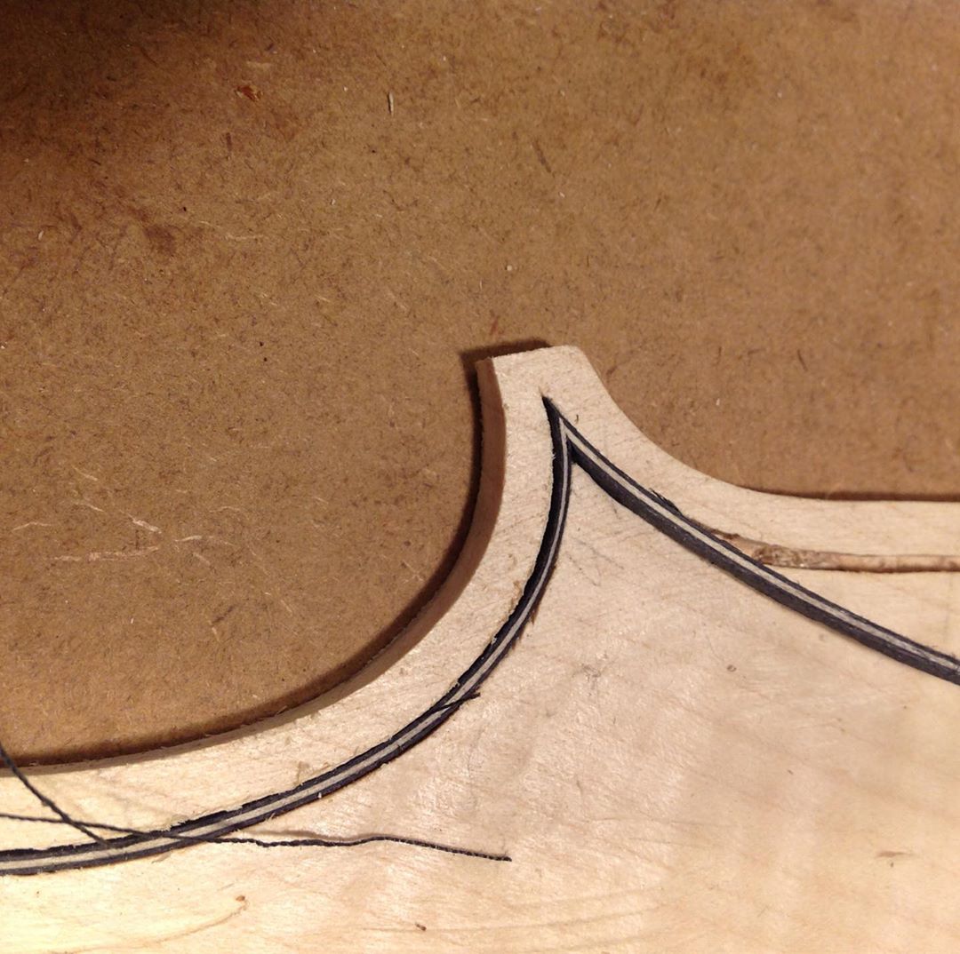 Sebastian: Fitting the purfling corners. Purfling is decorative, but also protective. The purfling is a thin inlay that protects the plates from cracks. If the instrument is knocked against a desk, or music stand (happens often), then the purfling will inhibit any cracks from going into the plates